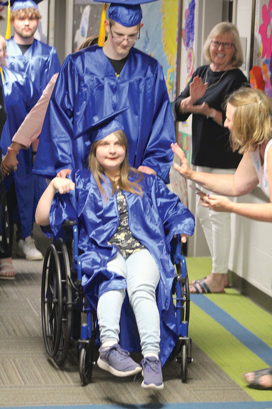 Athenian senior Bailey Lowe-Harwood makes her way through the crowd at Hose Elementary, receiving “high fives” and “congratulations” from students and staff along the way.